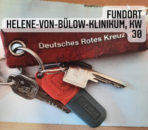 Bild vergrößern: Ein Schlüsselbund wurde bei der Helene-von-Bülow-Straße gefunden. Am Schlüsselbund befindet sich ein roter Anhänger mit der Aufschrift "Deutsches Rotes Kreuz" und ein rot-grauer Token, sowie 2 Schlüssel.